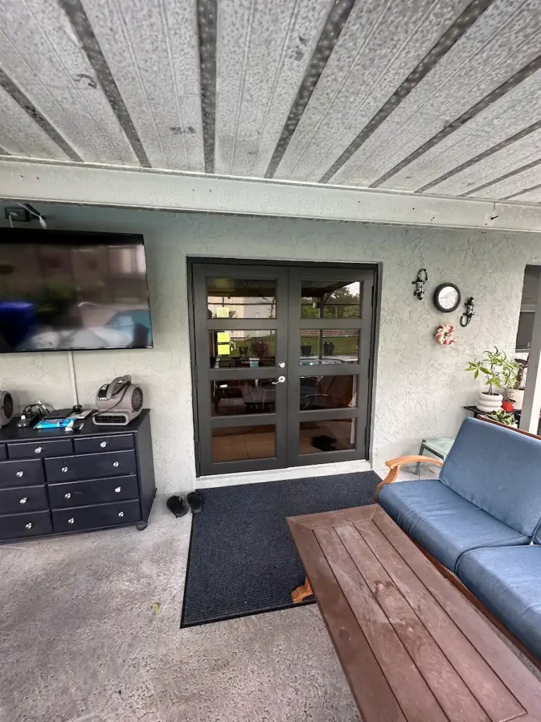 Modern glass French doors installed on a covered patio by NF Home Improvements in Loxahatchee, FL